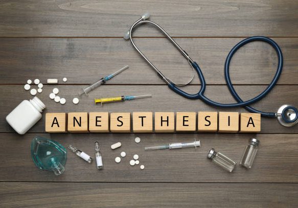 Flat lay composition with word Anesthesia made of cubes and drugs on wooden table