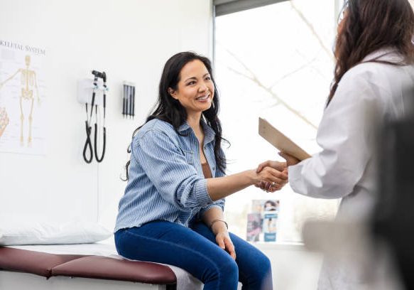 Arriving for her appointment, the unrecognizable female doctor shakes hands with her patient.